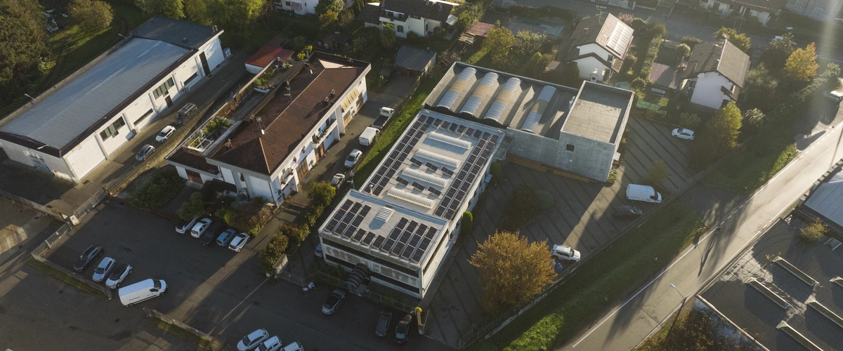 Vista aerea della sede aziendale di fluid-hub con magazzino, pannelli solari sul tetto e parcheggio